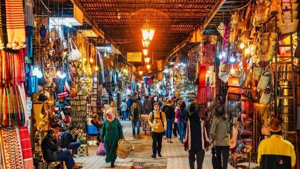 People are walking in one of narrow streets in the souk of Marrakech